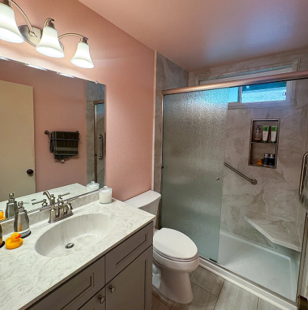 Bathroom remodel in Oxnard with new vanity, shower enclosure, and tile surround